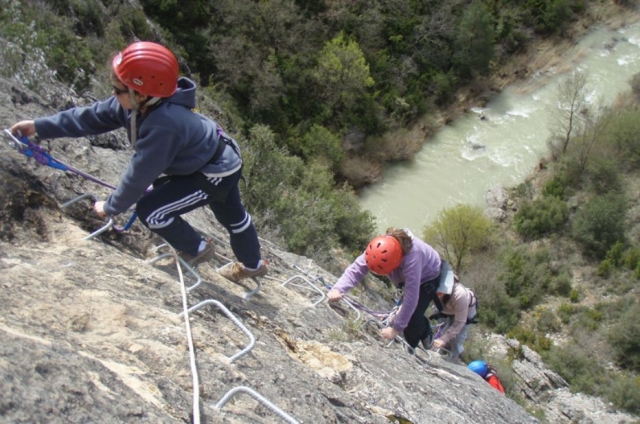 ninos subiendo una pared con escalones metalicos